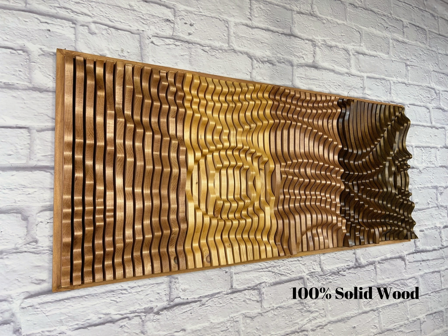 Close-up of SUNRISE Parametric Wall Art mounted on a white brick wall, showcasing 3D wood texture and natural acoustic panel design.